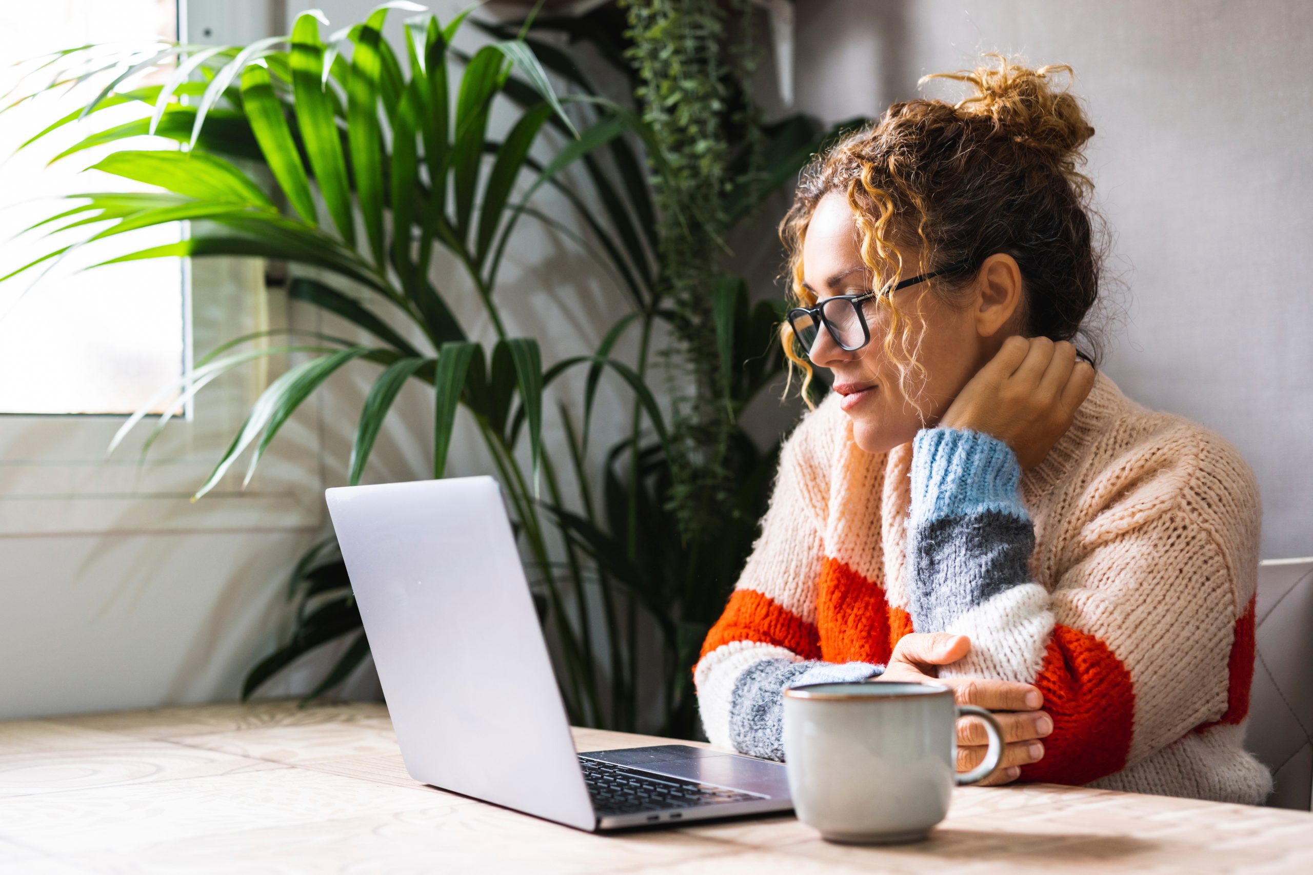 woman looking and reading on laptop