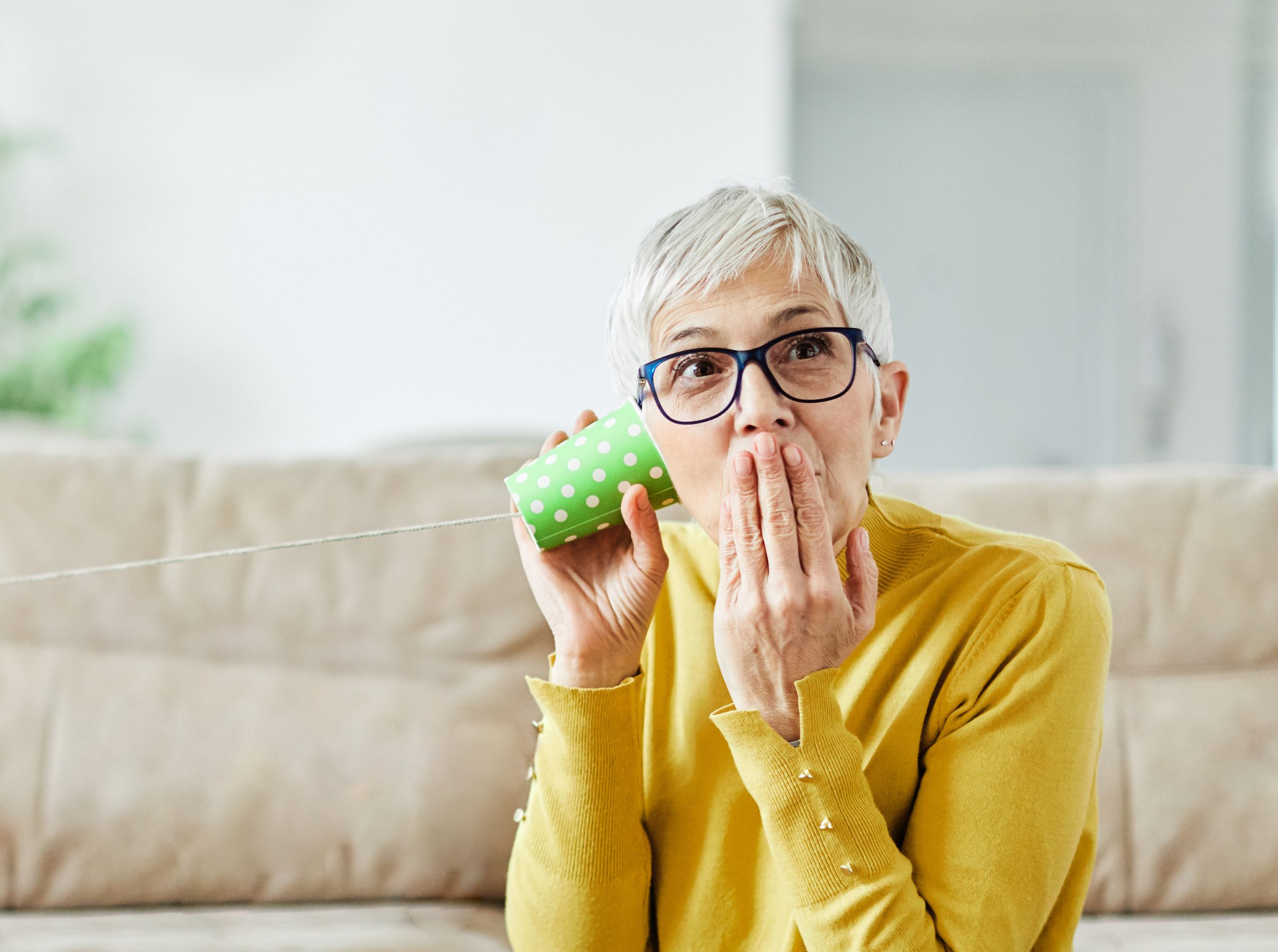 Woman using cup telephone