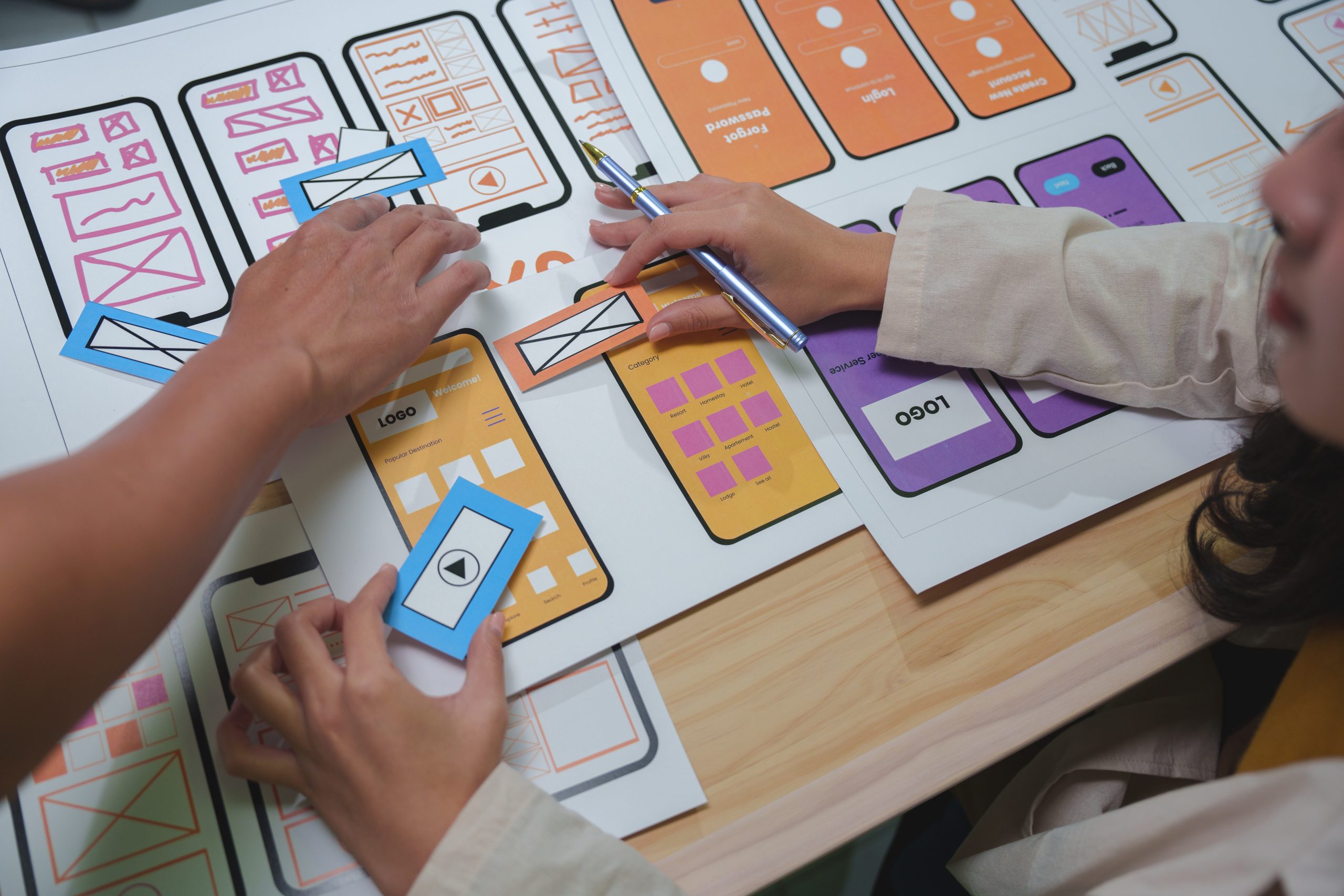 Web designers arranging colorful paper cutouts